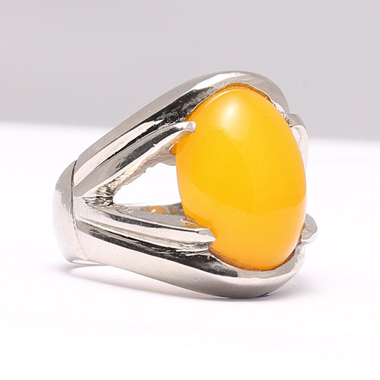 A silver ring with a yellow aqeeq agate stone set in a polished, silver-tone band.